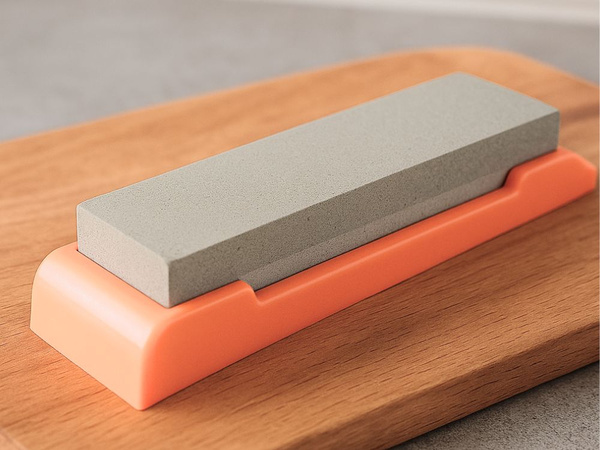 Stone sharpener for knives and scissors, double-sided, rectangular, on a base