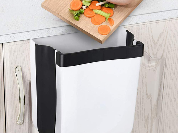 Salokāms grozs bioloģiskajiem atkritumiem, kas karājas uz skapja